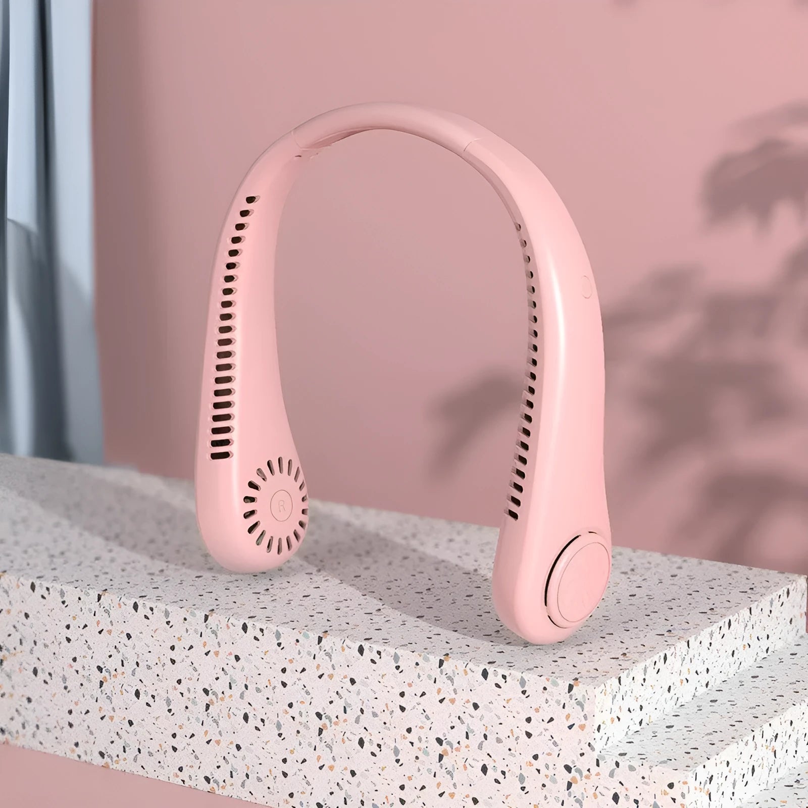 Pink USB rechargeable bladeless neck fan hanging on a mannequin neck