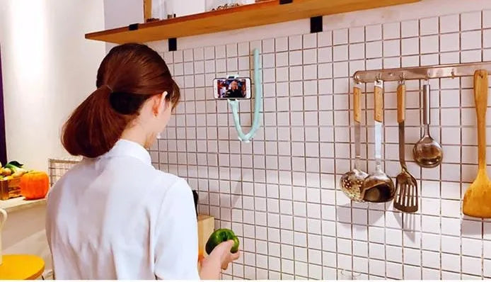 Flexible mobile phone holder with suction cup on desktop showing 360-degree rotation