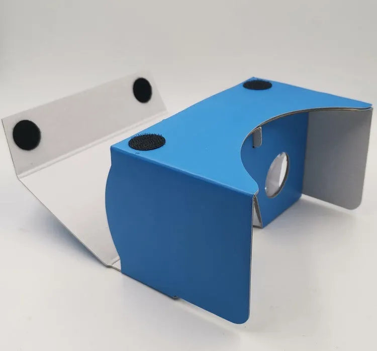 Pink and white foldable cardboard VR glasses headset for smartphones, showing 3D lenses and rubber head strap.