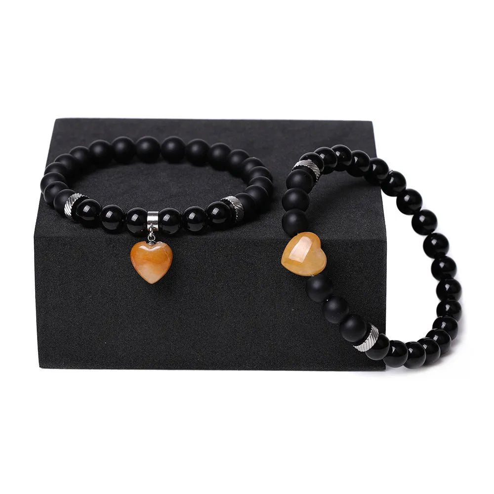 Natural stone couple bracelet set showing two matching bracelets with heart-shaped polished stone pendants