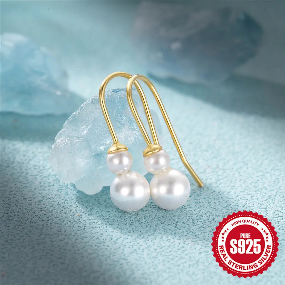 Golden coloured geometric sunflower sterling silver earrings with zircon inlay on a white background.