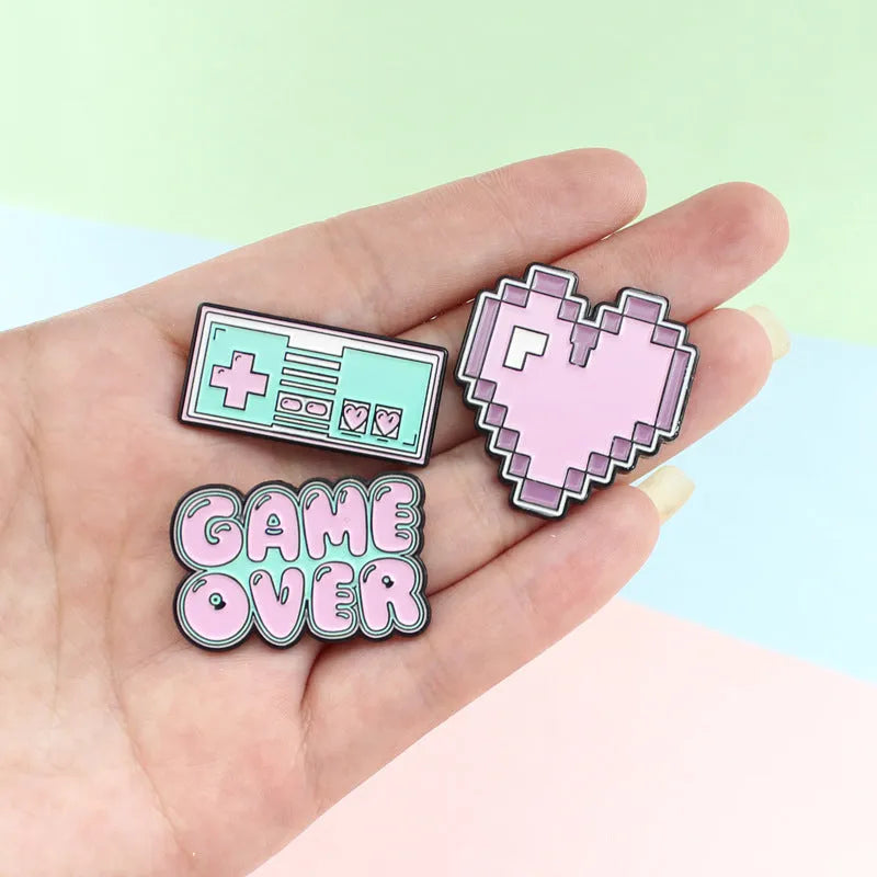 Stereo game console design metal badge with pin back, shown in one of three alloy colour options.