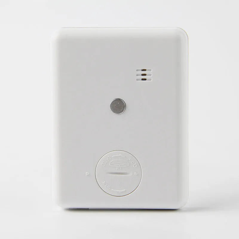 Black and white digital kitchen timer with magnet back on a refrigerator