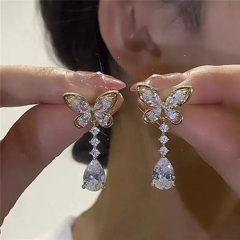 A pair of women's bow-shaped stud earrings with a platinum-coloured electroplated finish.