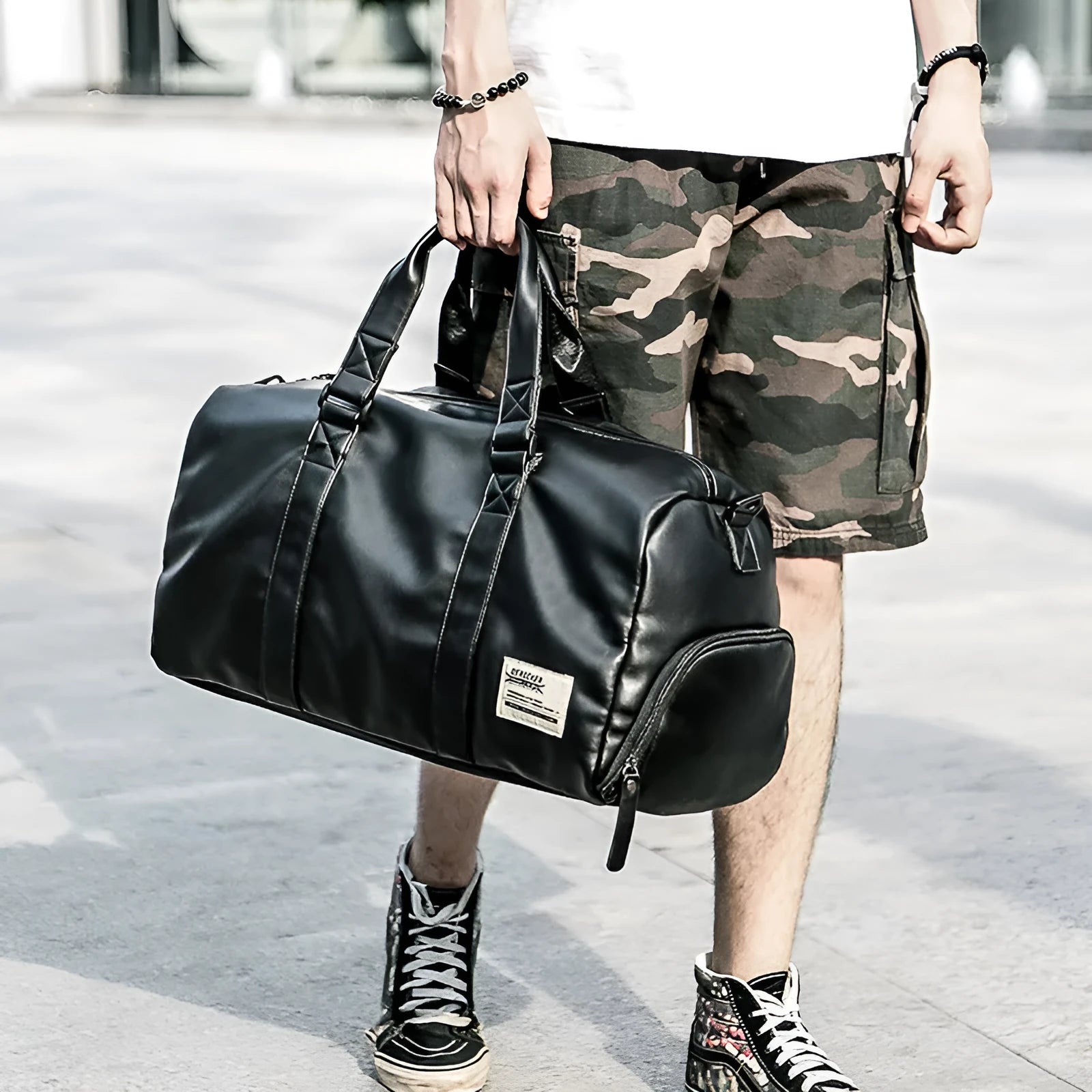 Black waterproof PU leather sports training bag showing internal organisation pockets and shoulder strap