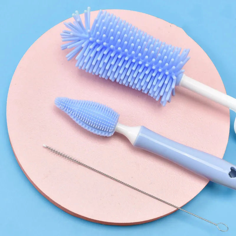 Silicone baby bottle brush with straw cleaning attachment in pink, blue, and yellow colours