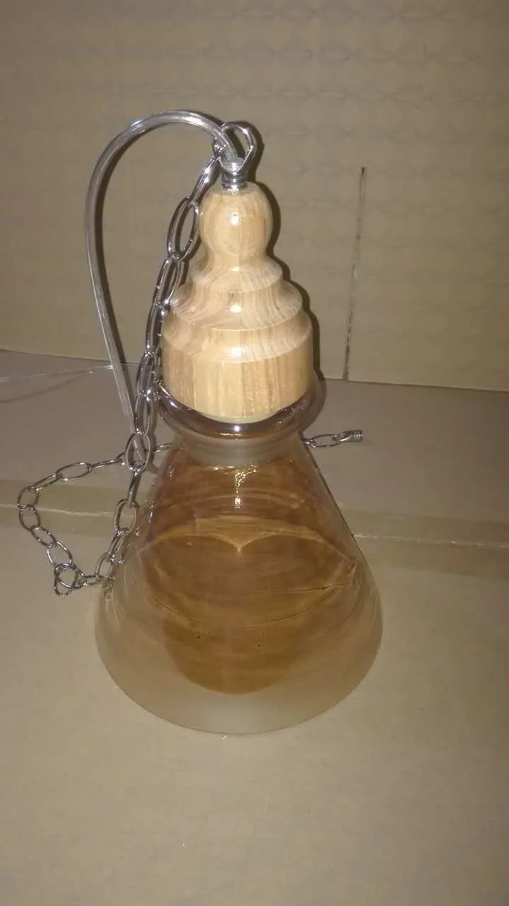 Nordic style single head pendant light with wood grain glass shade on an adjustable cable.