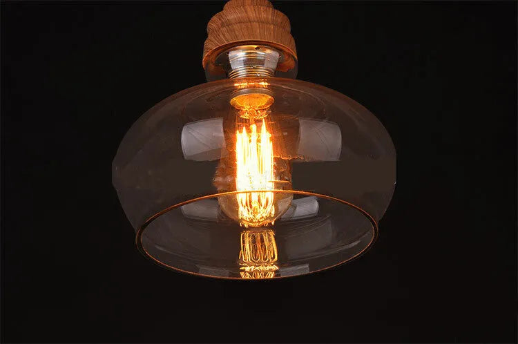 Nordic style single head pendant light with wood grain glass shade on an adjustable cable.