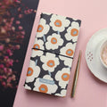 TN soft cover hand notebook in a choice of five colours, shown open on a desk.