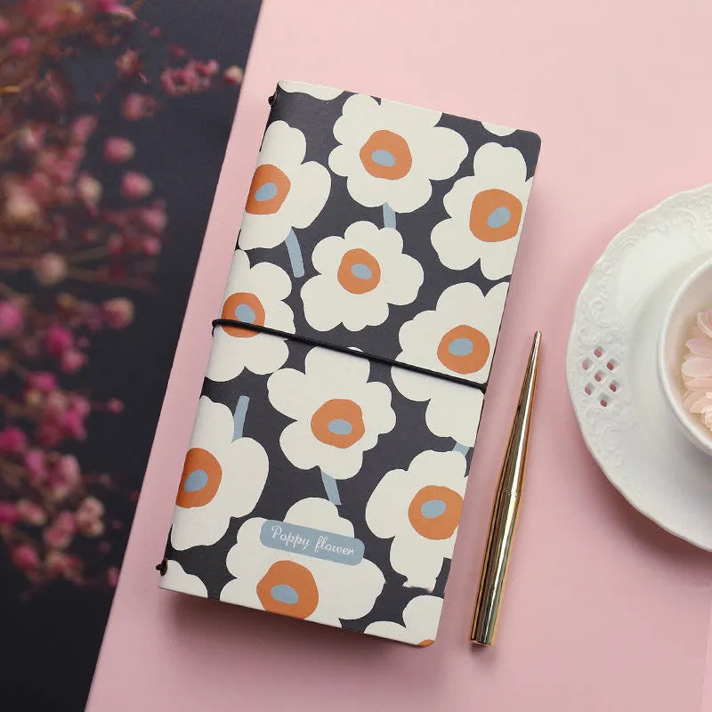 TN soft cover hand notebook in a choice of five colours, shown open on a desk.