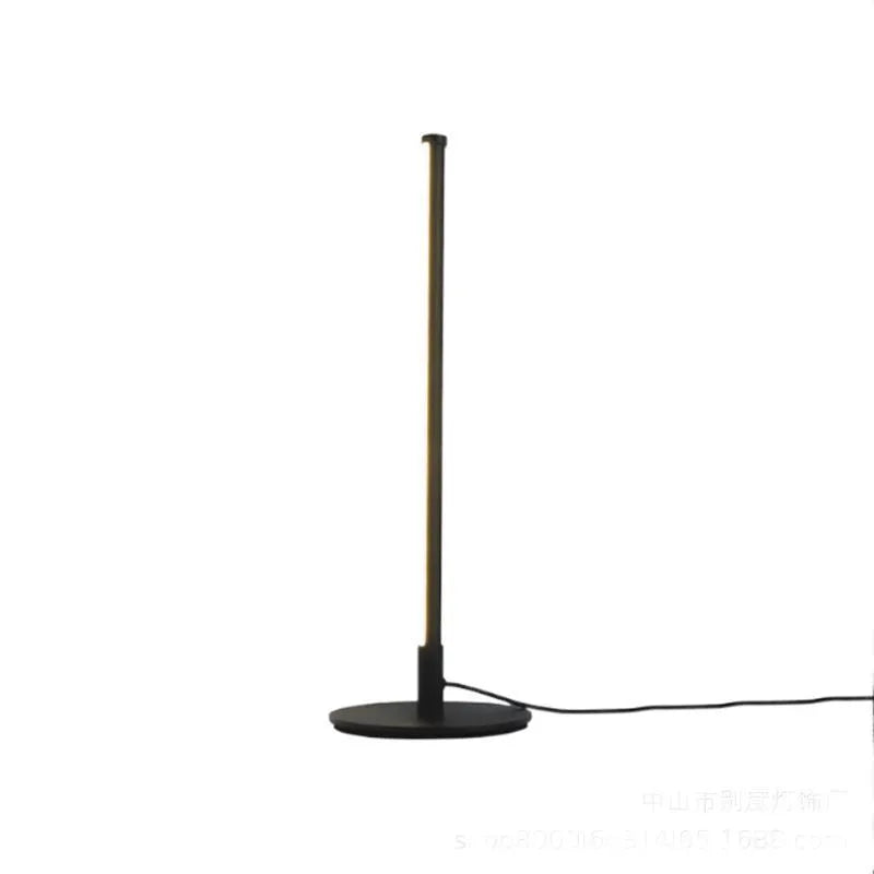 Tall black Nordic minimalist table lamp with RGB LED light on a wooden bedside table.