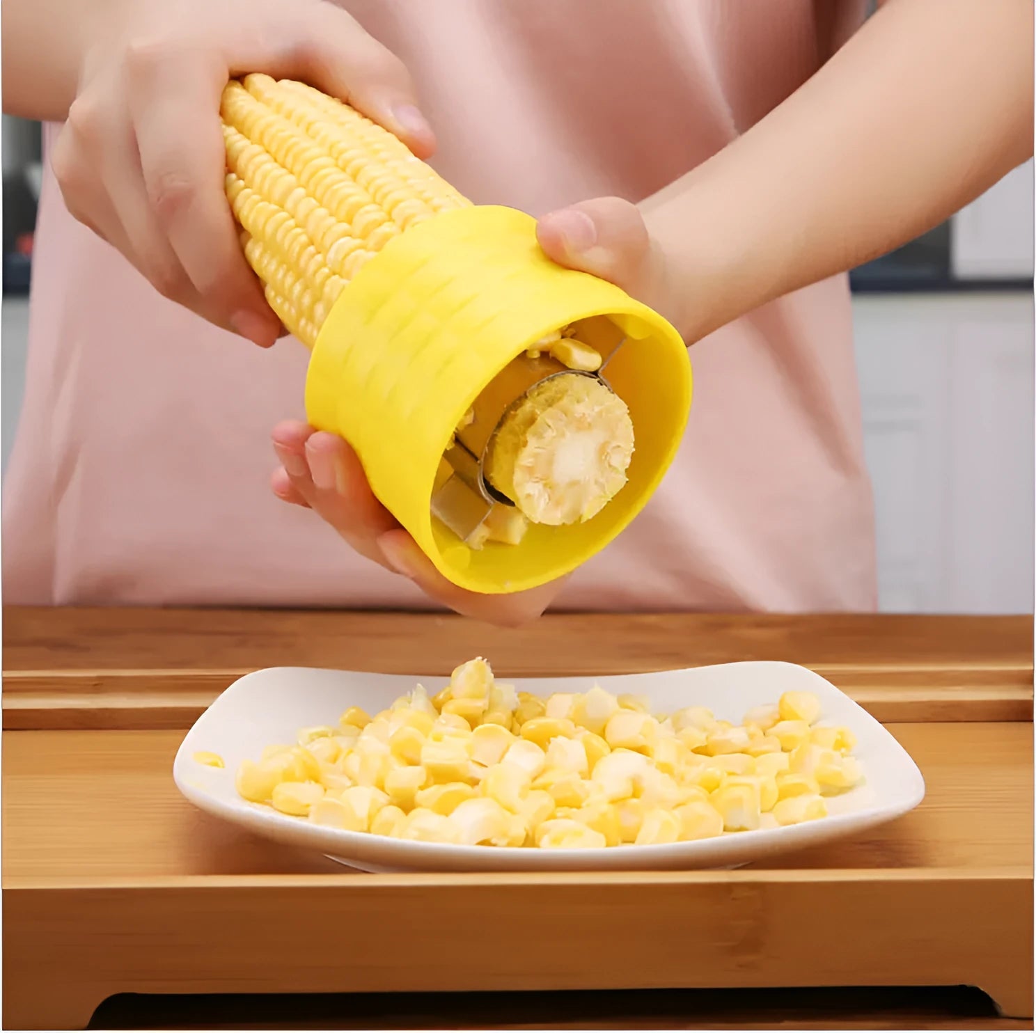 Yellow manual corn grinder thresher tool with corn-shaped design on a kitchen counter.