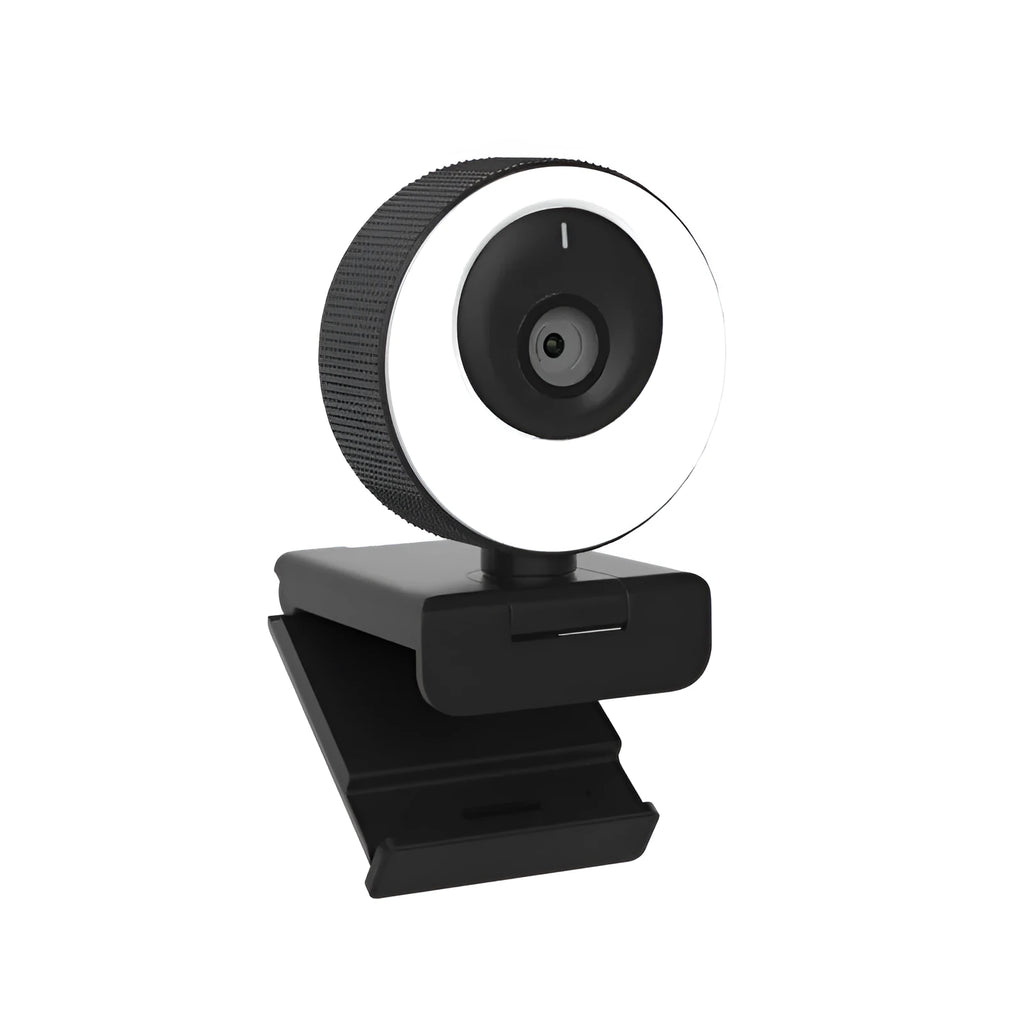 Black USB computer webcam with a magnetic privacy cover on a desk next to a laptop.