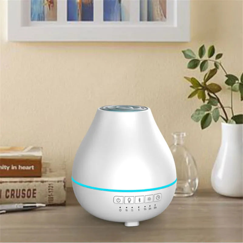 Round white Bluetooth humidifier and aroma diffuser with night light on a wooden surface.