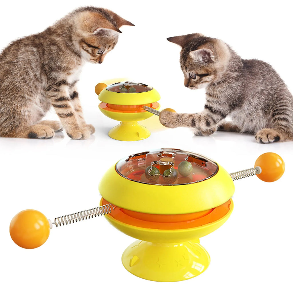 Rotating turntable cat toy with transparent top showing catnip balls, in lake blue colour with a large white suction cup base.