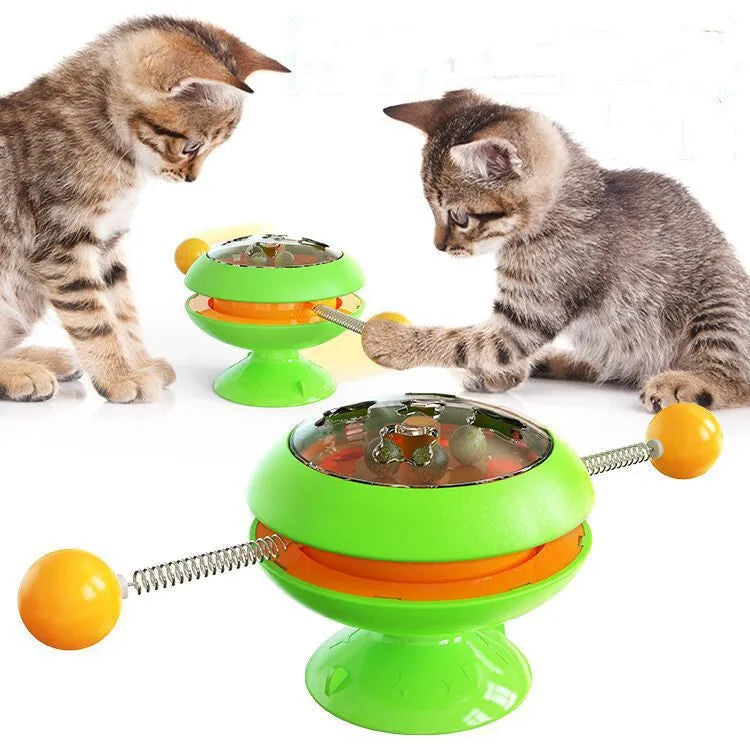 Rotating turntable cat toy with transparent top showing catnip balls, in lake blue colour with a large white suction cup base.