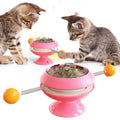 Rotating turntable cat toy with transparent top showing catnip balls, in lake blue colour with a large white suction cup base.