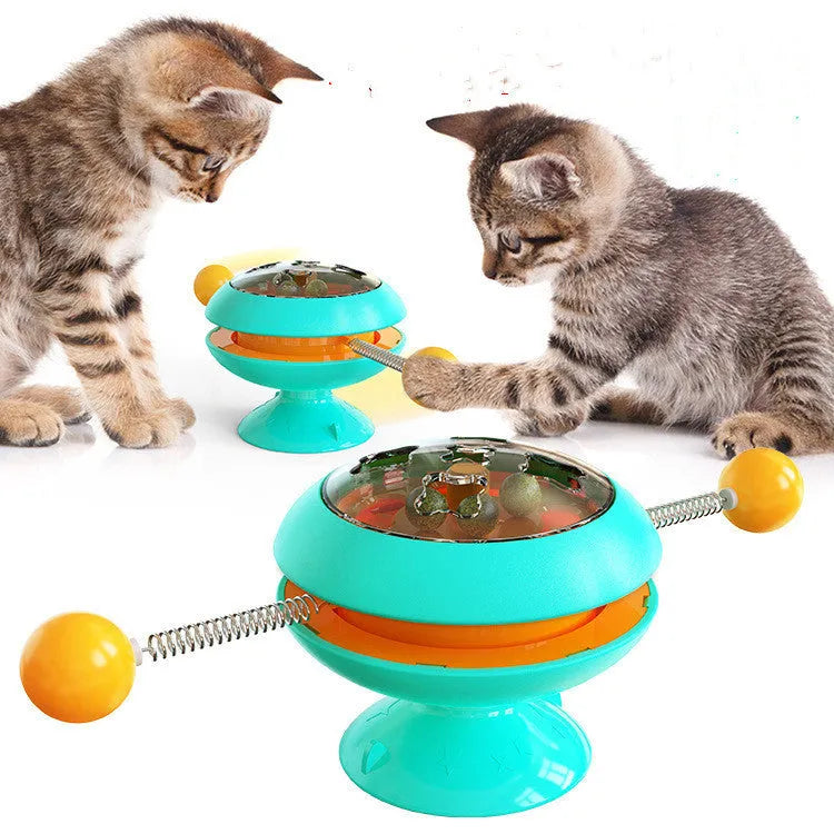 Rotating turntable cat toy with transparent top showing catnip balls, in lake blue colour with a large white suction cup base.