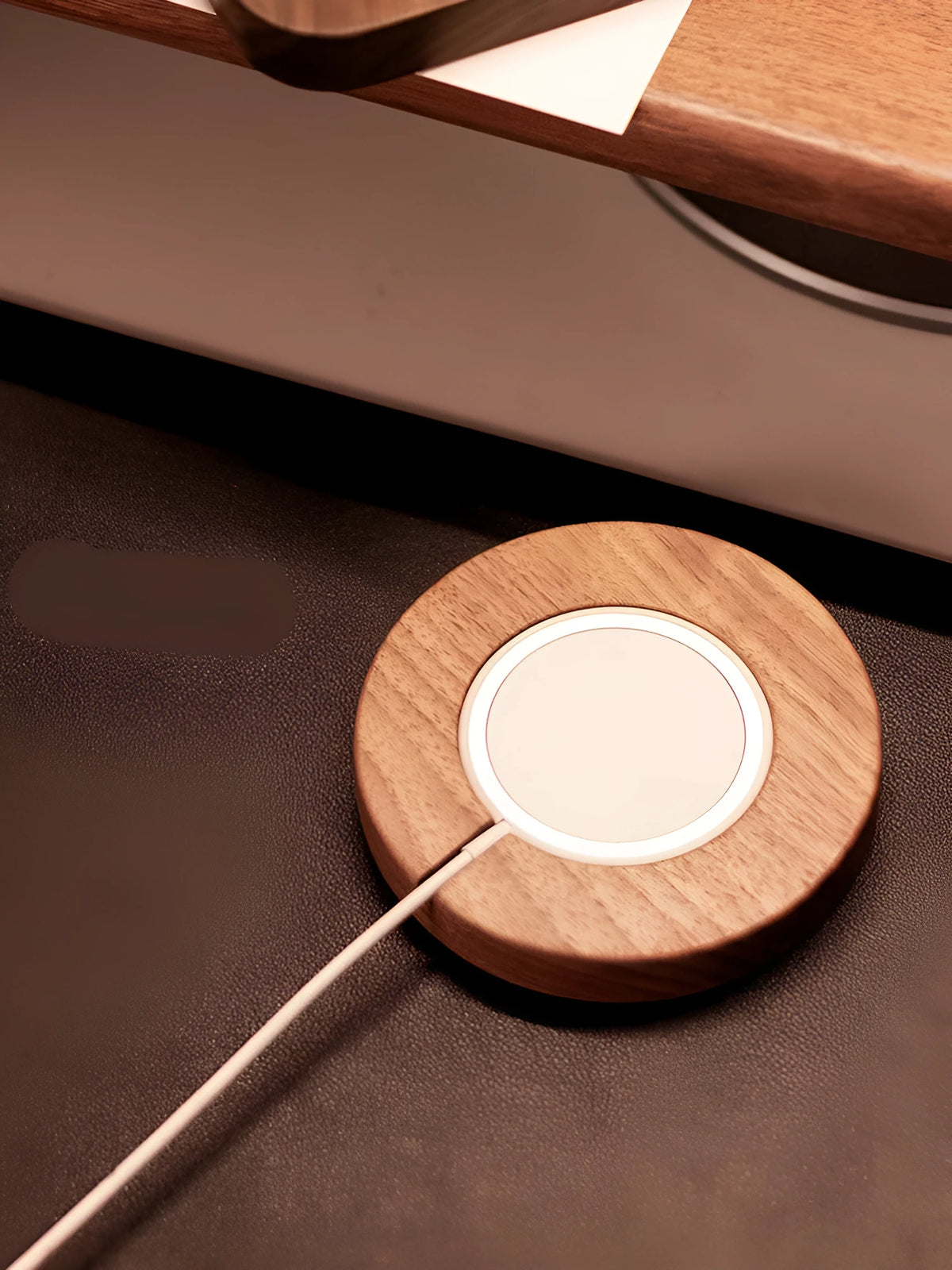 Walnut wood magnetic wireless charging base with phone attached on desktop