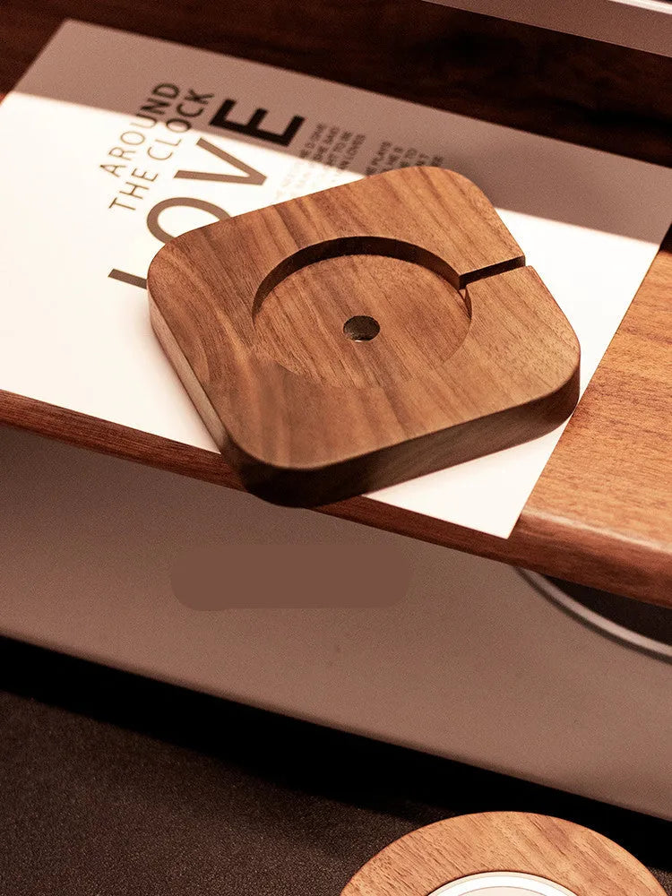 Walnut wood magnetic wireless charging base with phone attached on desktop