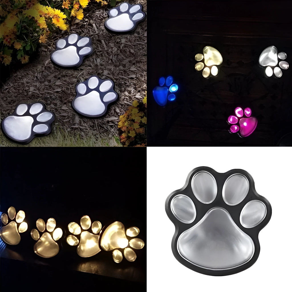 Black solar powered paw print garden lights with four LED lamps connected to a single stake, glowing on a garden path.