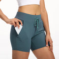 Women's summer stretch training shorts with pockets in nylon blend, shown in black, blue, green, purple, and rose red, sizes XS to XL.