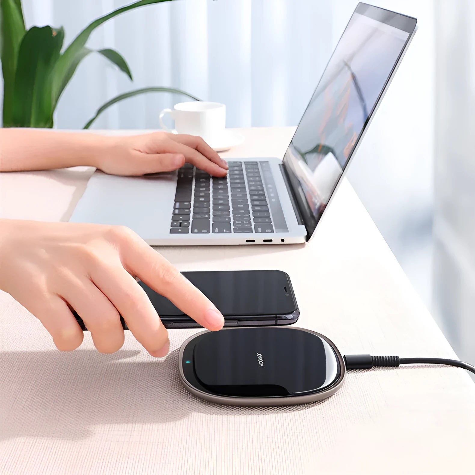 Black and white 15W wireless phone charger with zinc alloy and glass build on a desk.