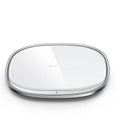 Black and white 15W wireless phone charger with zinc alloy and glass build on a desk.
