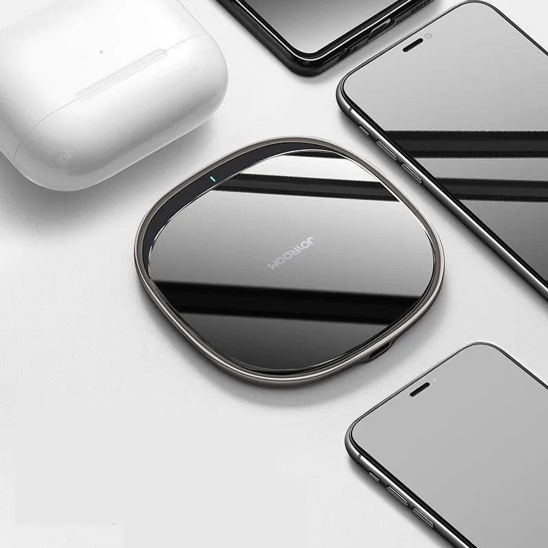 Black and white 15W wireless phone charger with zinc alloy and glass build on a desk.
