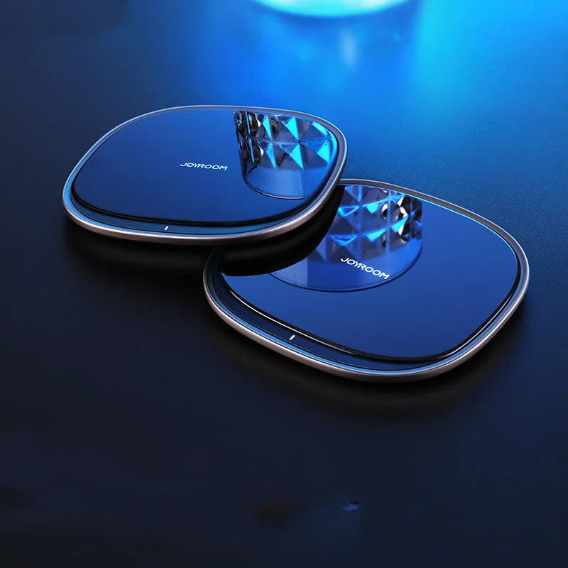 Black and white 15W wireless phone charger with zinc alloy and glass build on a desk.