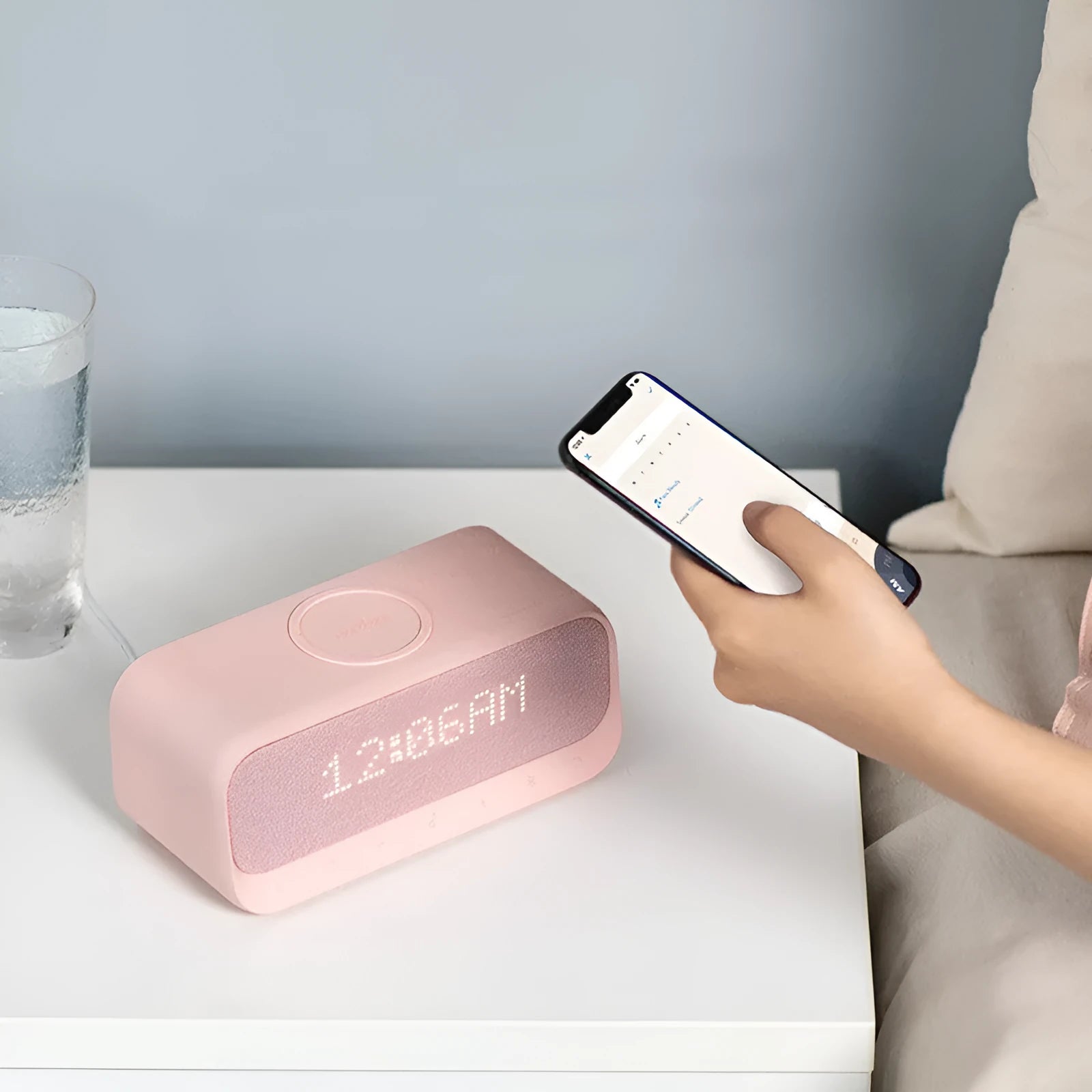 White Anker Soundcore Bluetooth speaker with wireless charging top and digital clock display