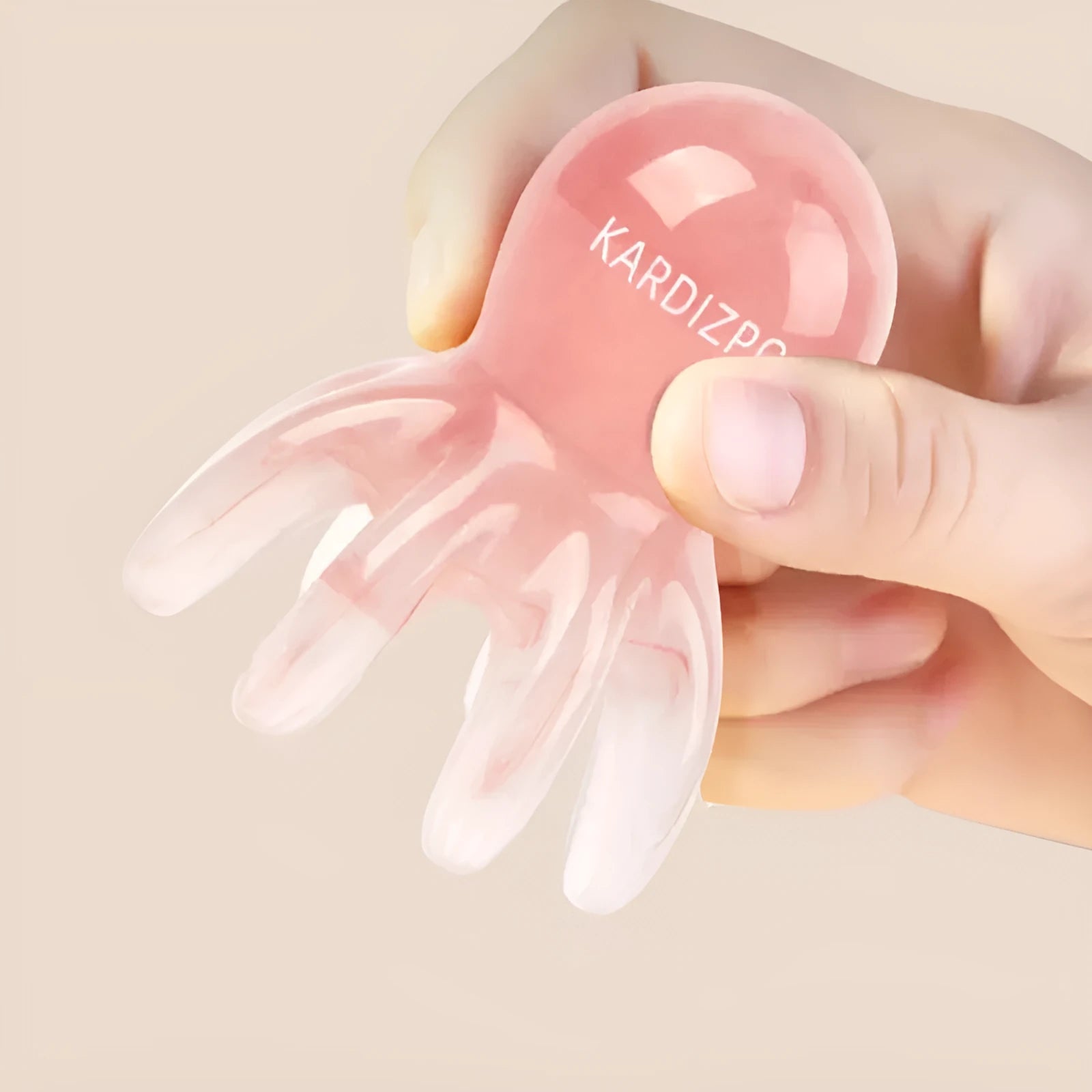 Pink octopus-shaped facial massage comb with dual-pronged tip for periocular pressure points