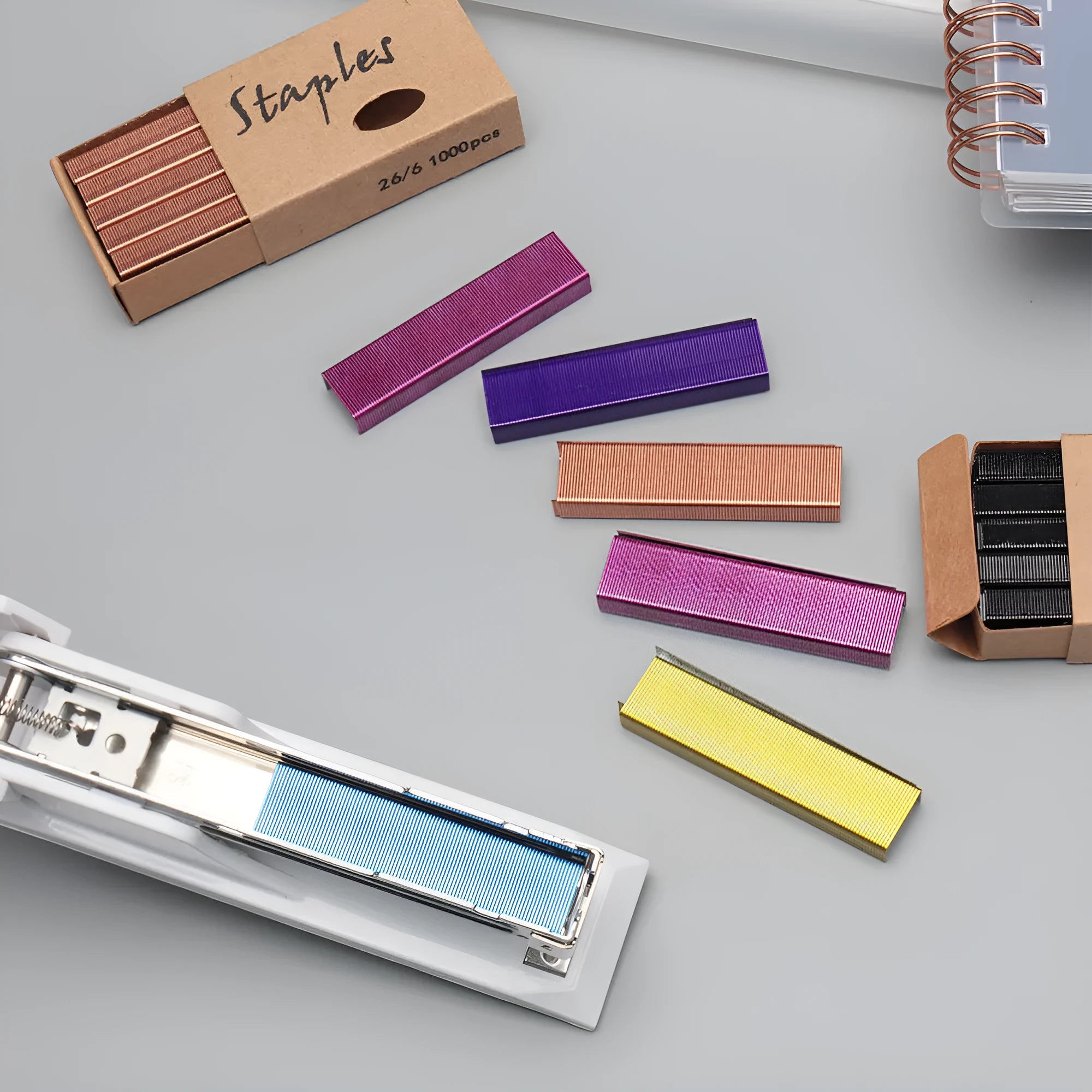 Box of 1000 metal office staples in black, purple, rose gold, and rose red colours