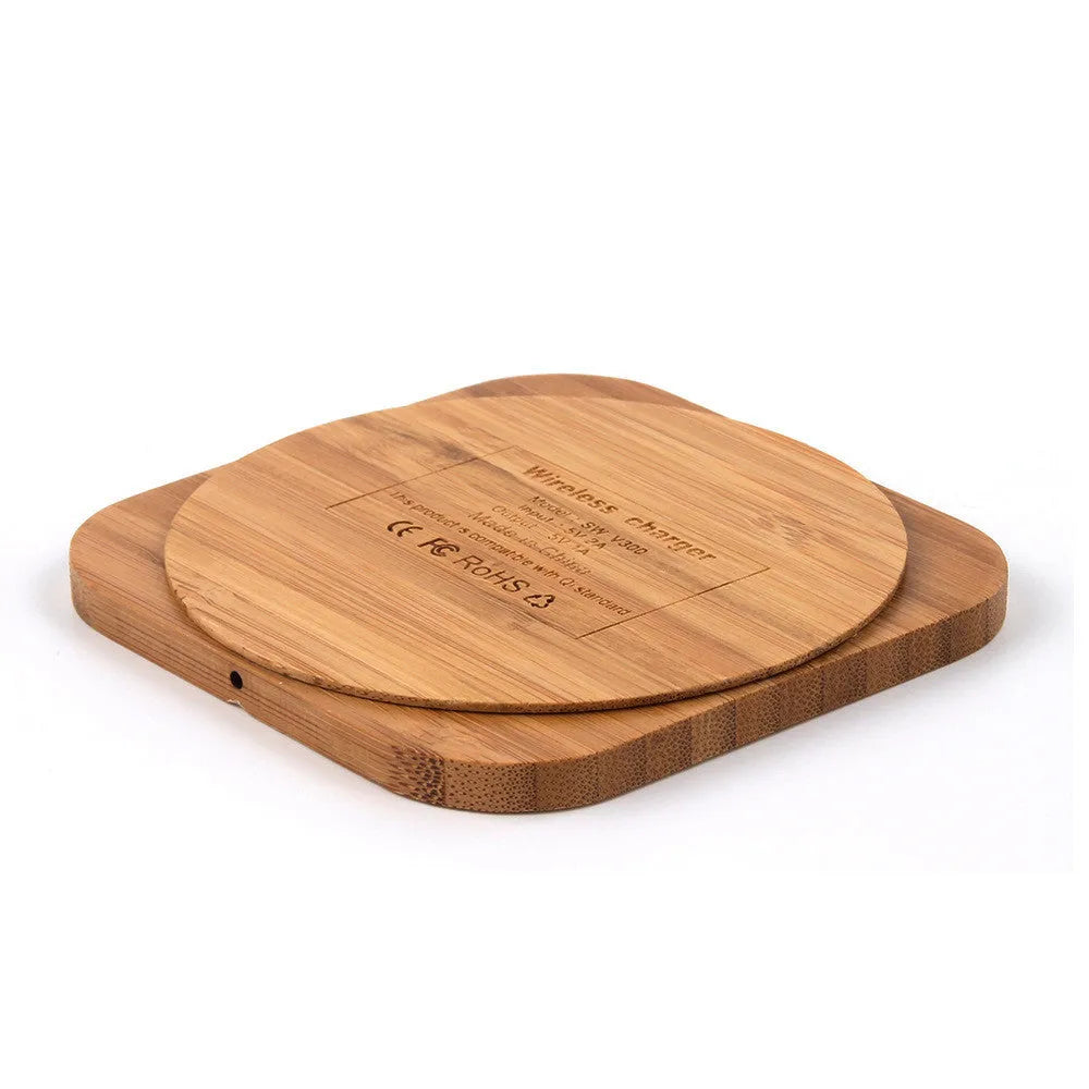 Square brown wooden bamboo 5W Qi wireless charging pad on a table.