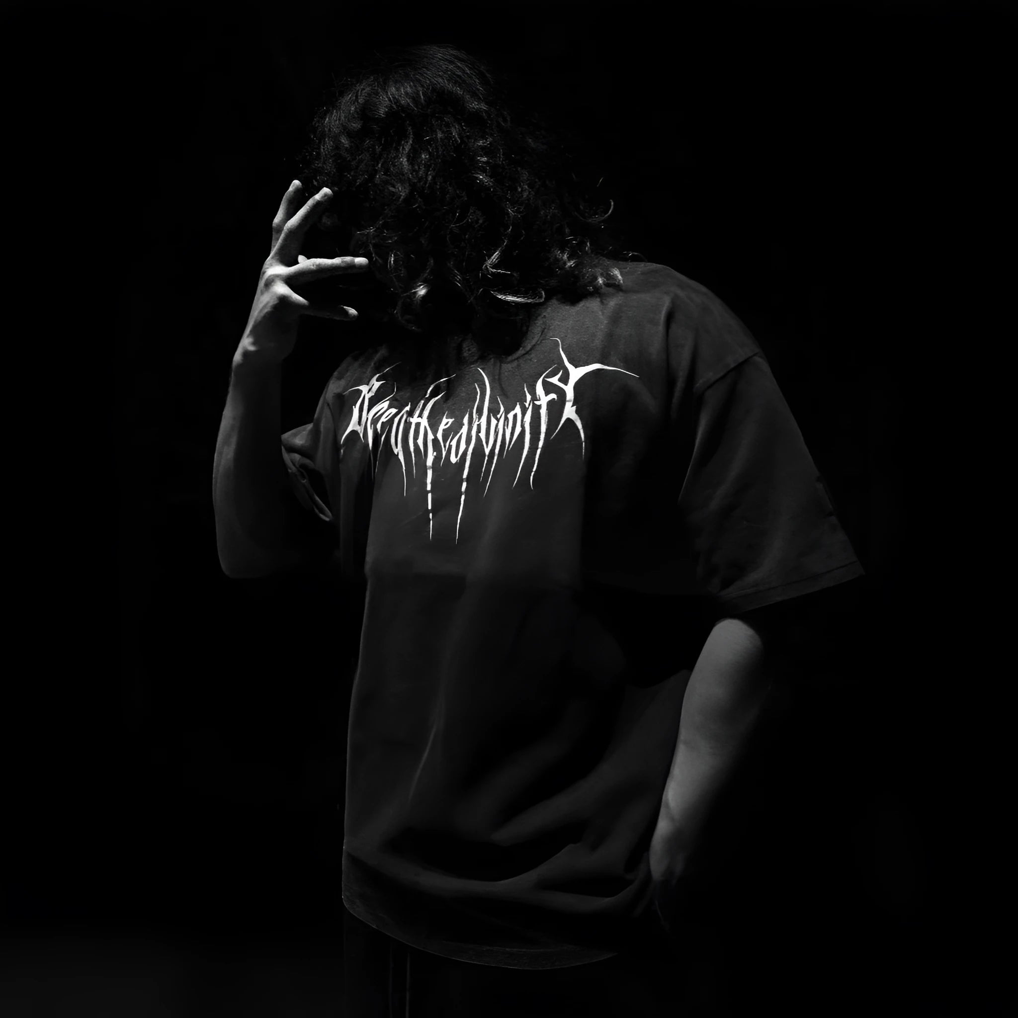 A dark coloured, loose-fitting plus size cotton short-sleeved T-shirt on a model, showing gilding craft detail.