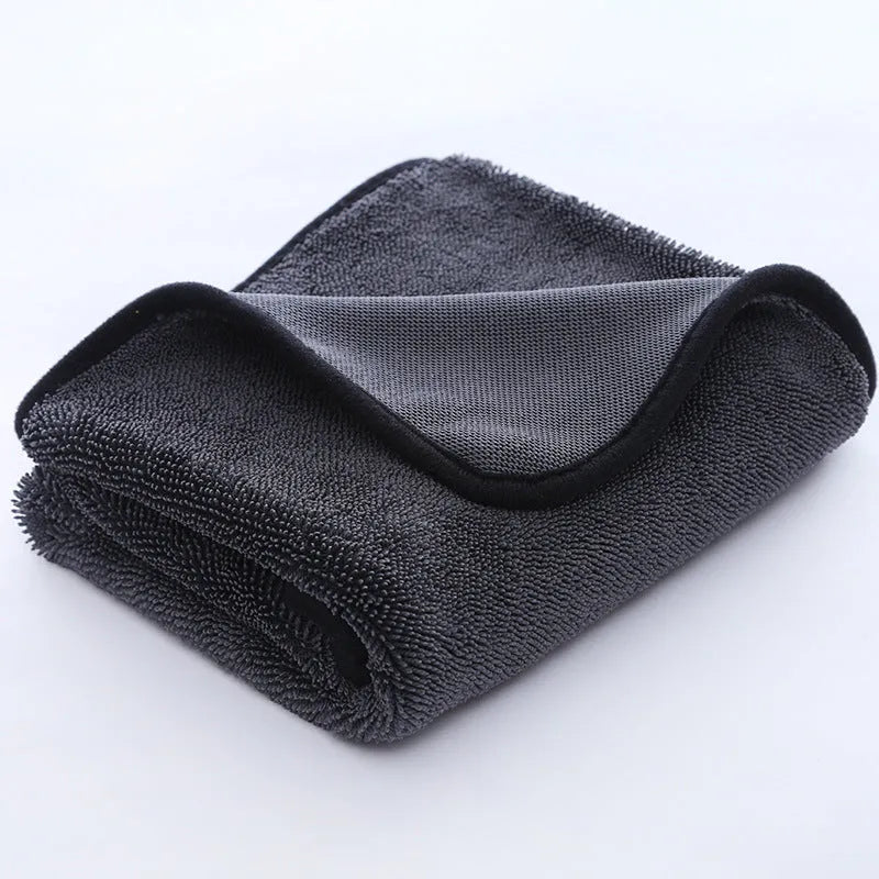 Grey car wash towel with black trim edge, showing hemmed border and spiral hair texture.