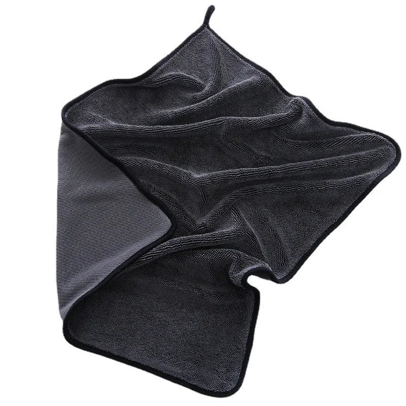 Grey car wash towel with black trim edge, showing hemmed border and spiral hair texture.