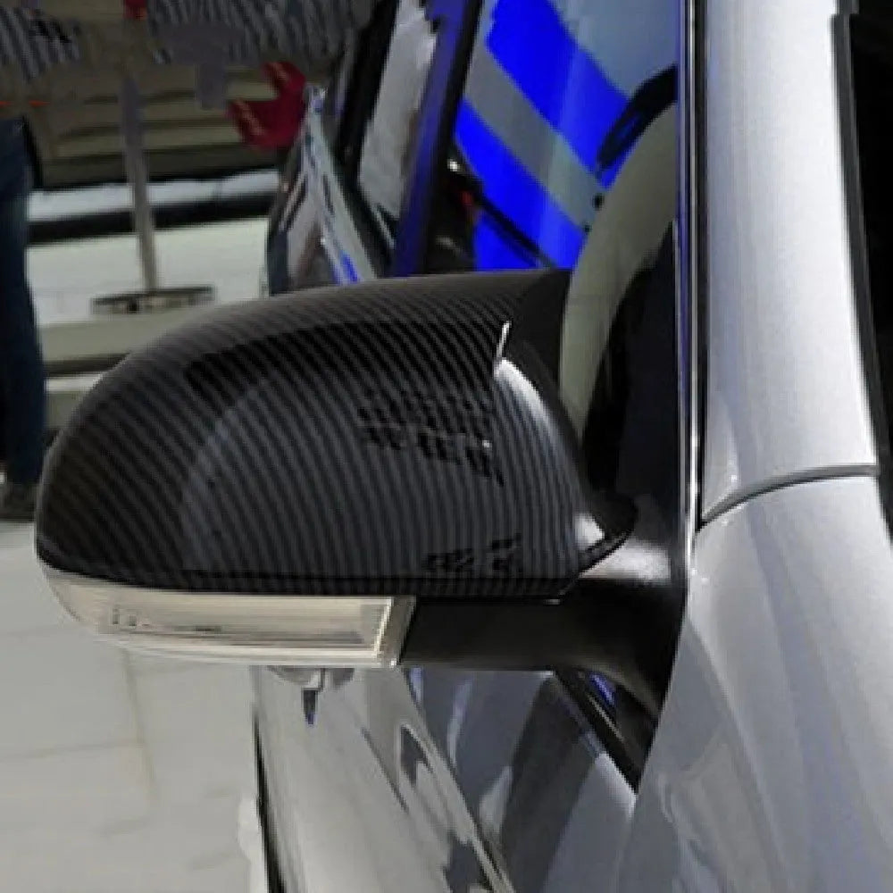Pair of plastic mirror housings for Volkswagen Old Sagitar in black and carbon fibre finishes.