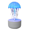 White jellyfish-shaped aroma diffuser and humidifier with glowing coloured LED light on a desk.
