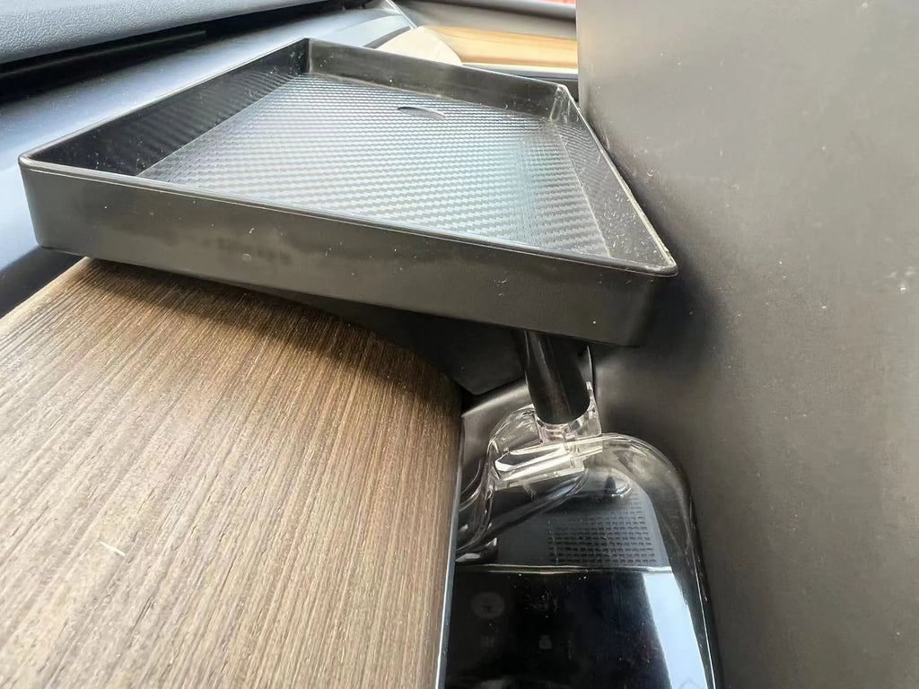 Black ABS plastic storage box installed under the touchscreen in a Tesla Model Y centre console.