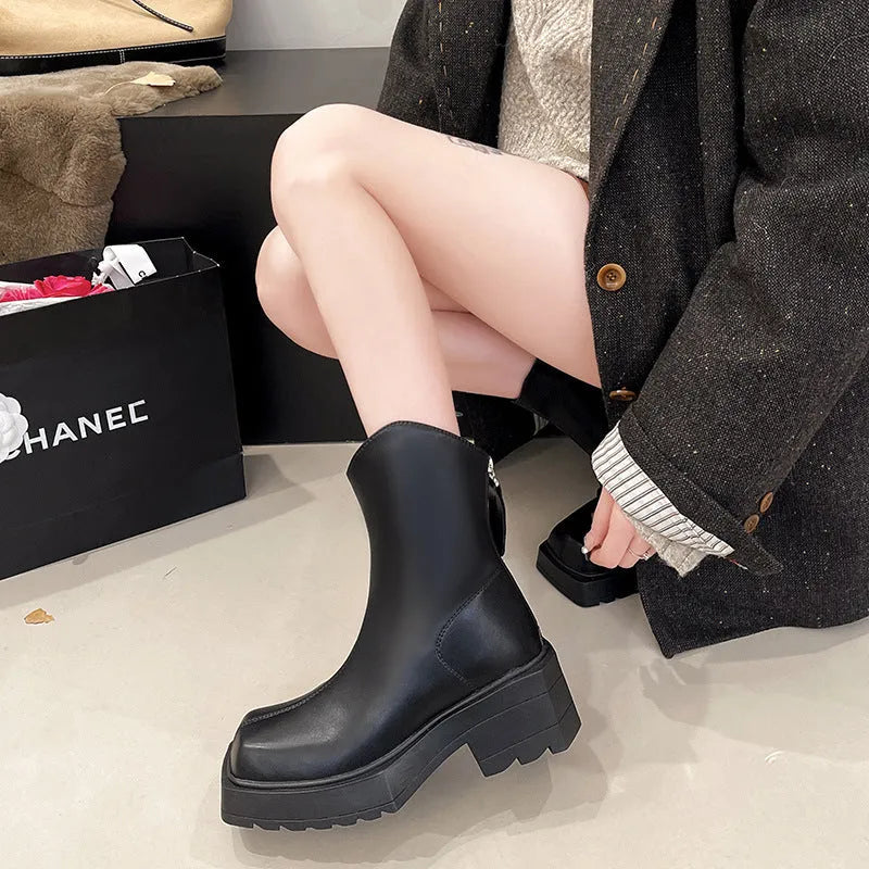 Women's black platform Martin boots with square toe, chunky heel, and back zipper on a plain background