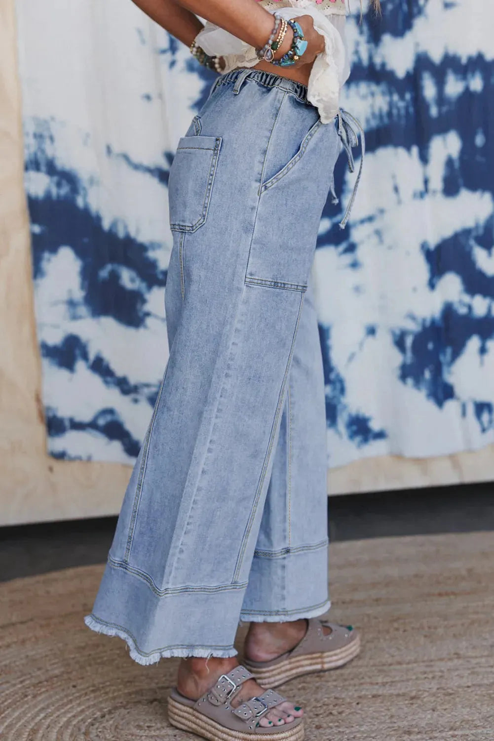 Beau Blue wide-leg women's jeans with a drawstring waistband and raw hem detail.