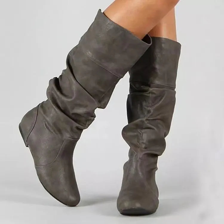 Women's flat heel slip-on ankle boot in artificial PU leather with a round toe and high cylinder sock.