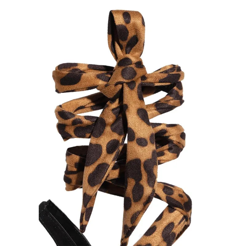 Light brown leopard print women's high heels with cross straps and a fine high heel.