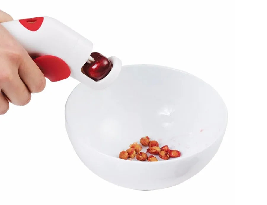 Stainless steel cherry kernel remover kitchen tool with red plunger and ergonomic handle.