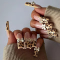 Leopard print butterfly design plastic nail art decorations set on a white background