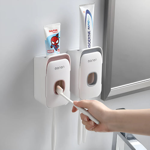 A blue automatic toothpaste dispenser mounted on a bathroom wall with a soft-touch button.