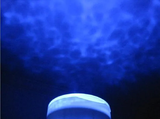 Blue stationary ocean projection lamp with DLP technology on a surface.
