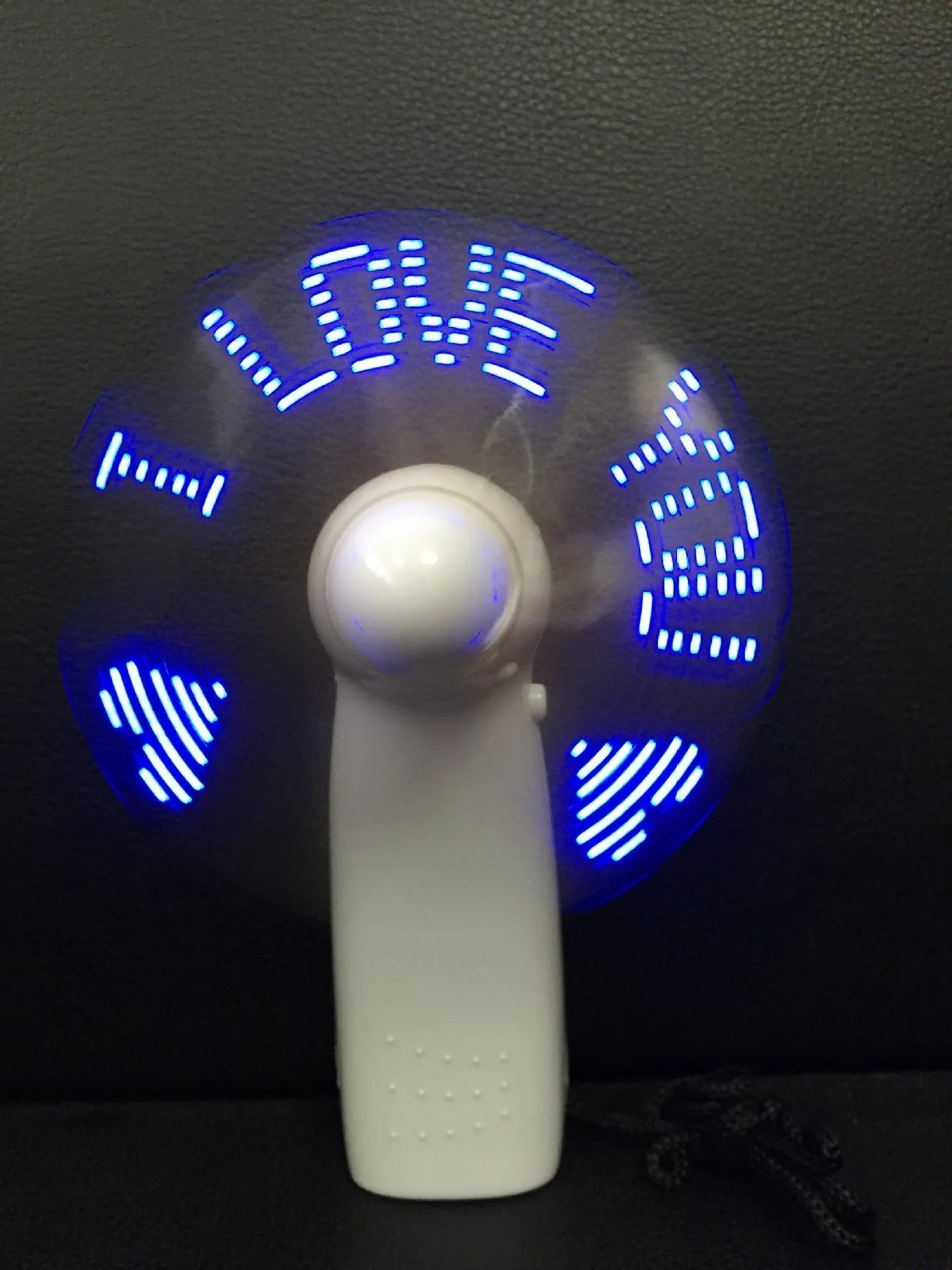 White handheld mini fan with blue and red LED lights flashing I love you pattern