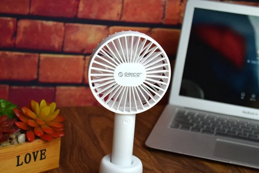 White ORICO FH1 portable USB desk fan with fine-line texture, shown as a handheld and desktop unit.